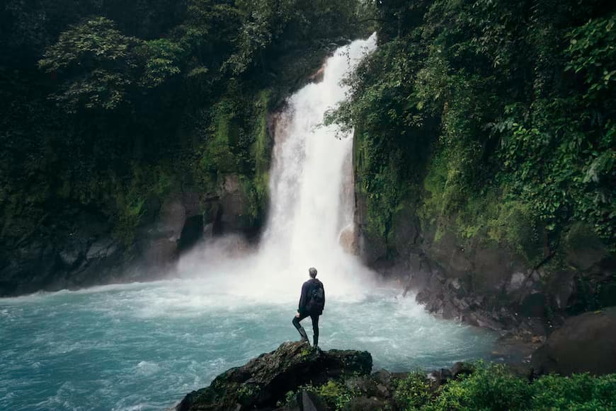 Man looking at a waterfall